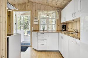 a kitchen with white cabinets and a large window at 710-Thisted-Klitrosevej-10 in Thisted +12 photos