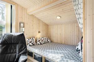 a bedroom with a bed in a room with wooden walls at 710-Thisted-Klitrosevej-10 in Thisted