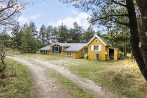 a yellow house on the side of a dirt road at 710-Thisted-Klitrosevej-10 in Thisted