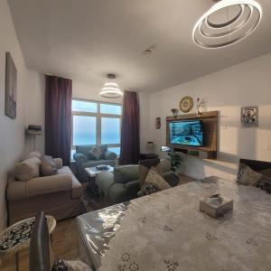 a living room with a couch and a tv at Royal Beach in King Abdullah Economic City