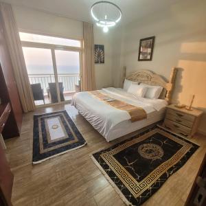 a bedroom with a large bed and a balcony at Royal Beach in King Abdullah Economic City +20 photos
