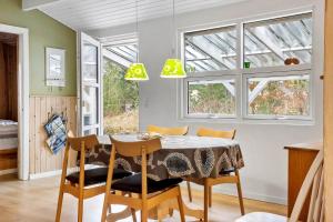 una sala da pranzo con tavolo, sedie e finestre di 873-Thisted-Blamunkevej-67 a Thisted