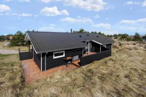 een zwart huis met een terras in een veld bij 980-Thisted-Spanggardsvej-35 in Torsted