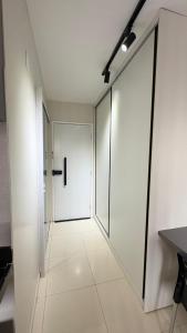 een hal met een witte deur en een tegelvloer bij Studio moderno Alu lounge 103 in São Luís
