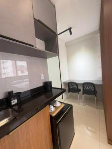 een keuken met een aanrecht en 2 stoelen in een kamer bij Studio moderno Alu lounge 103 in São Luís