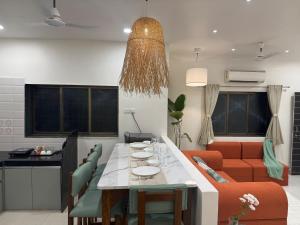 een woonkamer met een tafel en een bank bij AT Alibaug - A Boho Boutique Stay in Alibaug