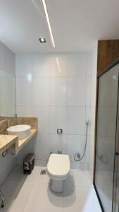 een witte badkamer met een toilet en een wastafel bij Studio moderno Alu lounge 103 in São Luís