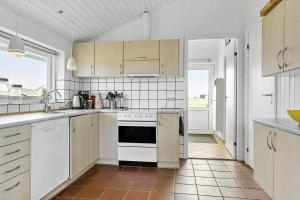 eine Küche mit weißen Geräten und weißen Schränken in der Unterkunft 760 Thisted - Pighvarvej 30 in Thisted + 11 Fotos