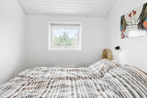 ein Bett in einem weißen Zimmer mit einem Fenster in der Unterkunft 760 Thisted - Pighvarvej 30 in Thisted