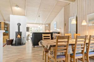 een eetkamer met een tafel en stoelen en een open haard bij 599-Thisted-Fiskervej-165 in Thisted
