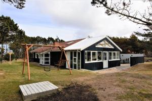 een huis met een schommel en een speeltuin bij 599-Thisted-Fiskervej-165 in Thisted