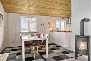 een keuken met een open haard, een tafel en een fornuis bij 928-Thisted-Kobbelsti-15 in Torsted