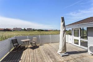 een houten terras met 2 stoelen en een tafel bij 928-Thisted-Kobbelsti-15 in Torsted