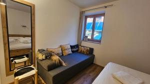 a living room with a couch and a mirror at Mountain Suite Brixen in Brixen im Thale