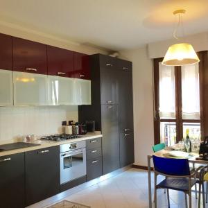 a kitchen with brown cabinets and a table with chairs at Appartamento Rosa in Padova