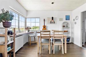 a dining room with a table and chairs and windows at 204-Vestervig-Lodbjergvej-4 in Vestervig