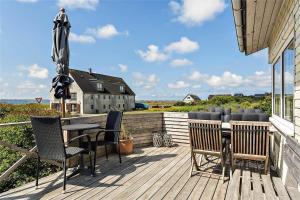 a deck with a table and chairs and an umbrella at 204-Vestervig-Lodbjergvej-4 in Vestervig