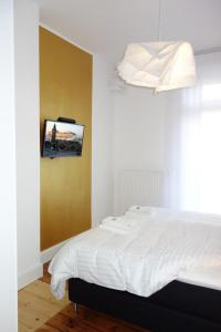 a bedroom with a bed with a tv on the wall at URBAN STAY Hamburg - Apartments Mitten im Herzen von Ottensen in Hamburg