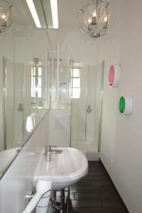 ein weißes Bad mit einem Waschbecken und einer Dusche in der Unterkunft URBAN STAY Hamburg - Apartments Mitten im Herzen von Ottensen in Hamburg