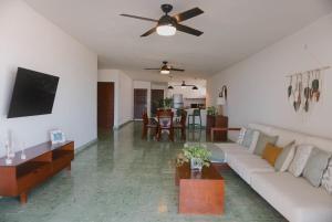 ein Wohnzimmer mit Sofa und Tisch in der Unterkunft Beach house Chuchos in Chelem