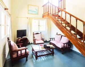 een woonkamer met een trap met stoelen en een tafel bij Alamos Hosteria in Mar Azul