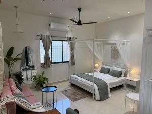 een slaapkamer met een hemelbed en een bank bij AT Alibaug - A Boho Boutique Stay in Alibaug