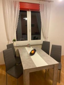 een eettafel met stoelen en een groot raam bij Ferienwohnung Fernblick in Bannewitz