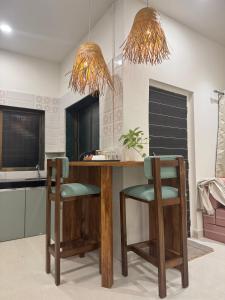 een keuken met een houten aanrecht en 2 stoelen bij AT Alibaug - A Boho Boutique Stay in Alibaug