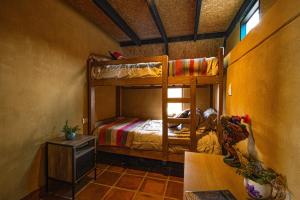 a bedroom with two bunk beds and a table at Cabaña mágica en Valle Sagrado in Cusco