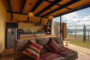 a living room with a couch and a large window at Cabaña mágica en Valle Sagrado in Cusco