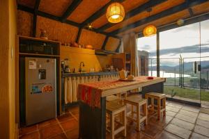 a kitchen with a refrigerator and a counter with stools at Cabaña mágica en Valle Sagrado in Cusco