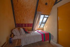 a small bedroom with a bed and a window at Cabaña mágica en Valle Sagrado in Cusco +7 photos