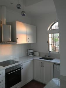 a kitchen with white cabinets and a sink and a window at Todosol Dream in Águilas