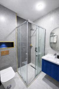 une salle de bains avec douche, toilettes et lavabo dans l'établissement Khatai Deluxe Hotel, à Baku