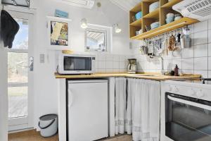 a white kitchen with a microwave and a stove at 1309-Thisted-Blabaervej-2 in Thisted +9 photos
