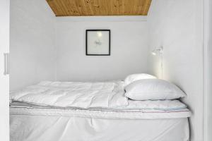 a bed with white sheets and pillows in a room at 1309-Thisted-Blabaervej-2 in Thisted