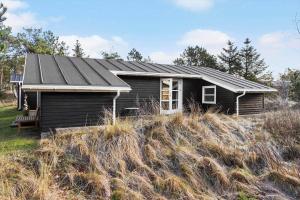 a black house on a hill in a field at 1309-Thisted-Blabaervej-2 in Thisted