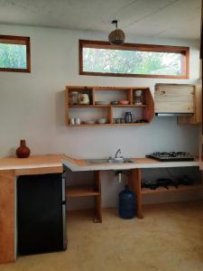 een keuken met een bureau, een wastafel en een raam bij Casa kuxtal in Zipolite +12 foto's