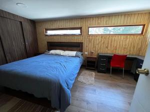 een slaapkamer met een bed en een bureau met een rode stoel bij Domo Algarrobo 1 in San Antonio