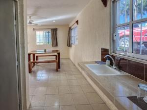 een badkamer met een wastafel, een tafel en een raam bij Sol y Luna Hospedaje in Valladolid