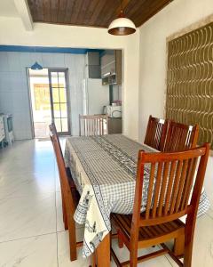 a dining room with a table and chairs and a kitchen at Casa completa Av Roberto da Silveira in Paraty +6 photos