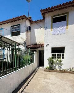 a white house with a fence in front of it at Casa completa Av Roberto da Silveira in Paraty