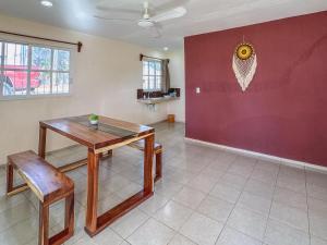 een eetkamer met een tafel en een rode muur bij Sol y Luna Hospedaje in Valladolid +38 foto's