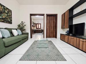 a living room with a green couch and a flat screen tv at Speranza in Il-Gżira