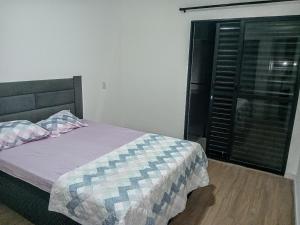 une chambre avec un lit et une fenêtre dans l'établissement Casa das Cachoeiras, à Botucatu 6 autres photos