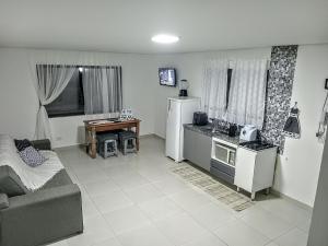 un salon avec un canapé et une cuisine dans l'établissement Casa das Cachoeiras, à Botucatu
