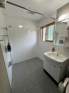 een witte badkamer met een wastafel en een spiegel bij Lodge Crea in Ujimi +76 foto's