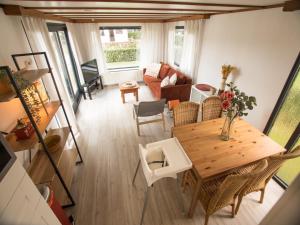 un soggiorno con tavolo e sedie in legno di Stay with Beach and Minigolf Views a Overbroek