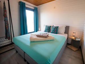 Schlafzimmer mit einem großen blauen Bett und einem Fenster in der Unterkunft Luxury Forest Lodge with Private Garden in Overbroek