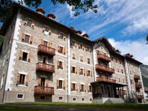 un grande edificio in pietra con balconi di Studio apartment with air conditioning a Ceresole Reale